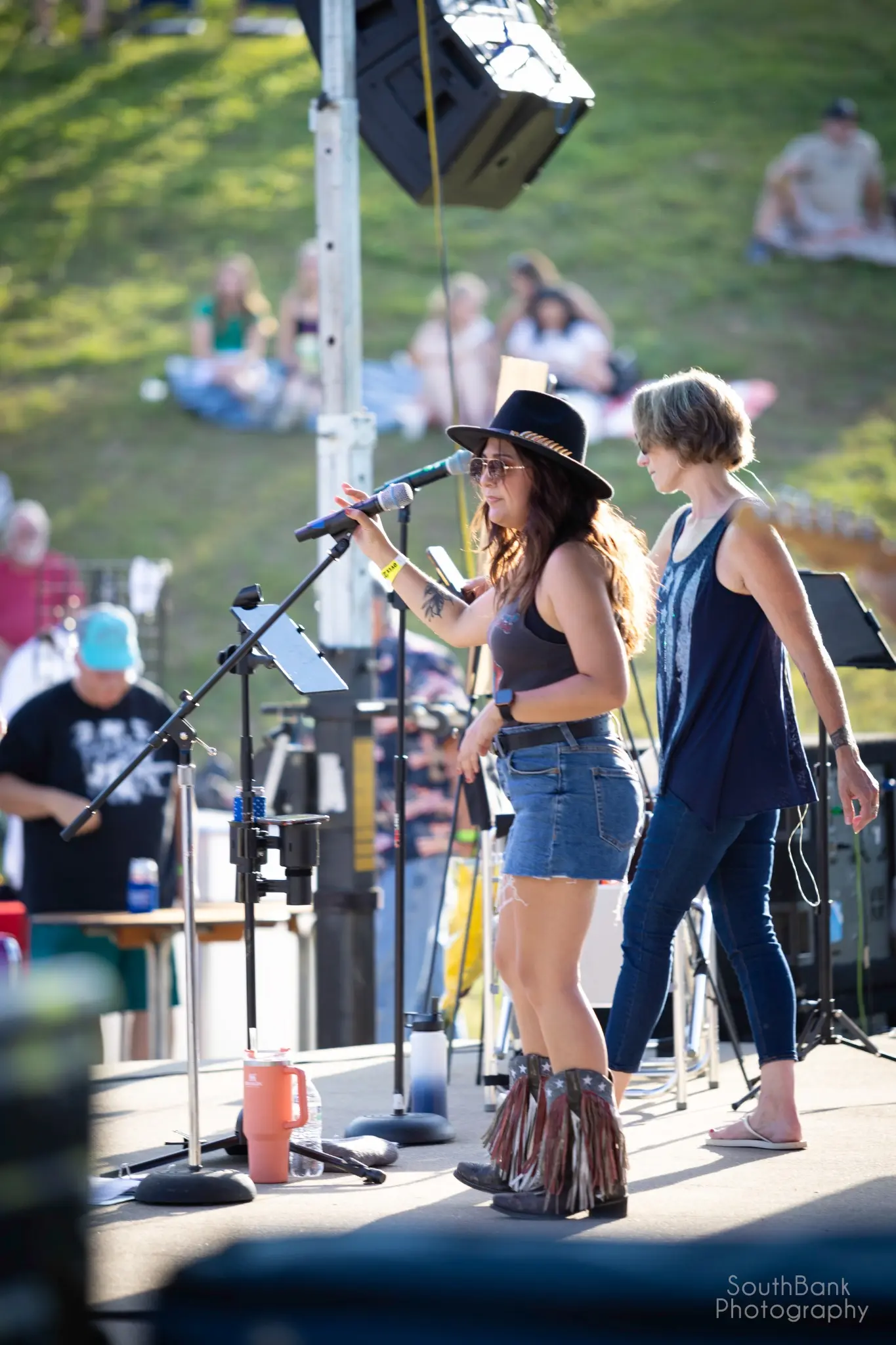 Two vocalists performing during an outdoor GenX concert
