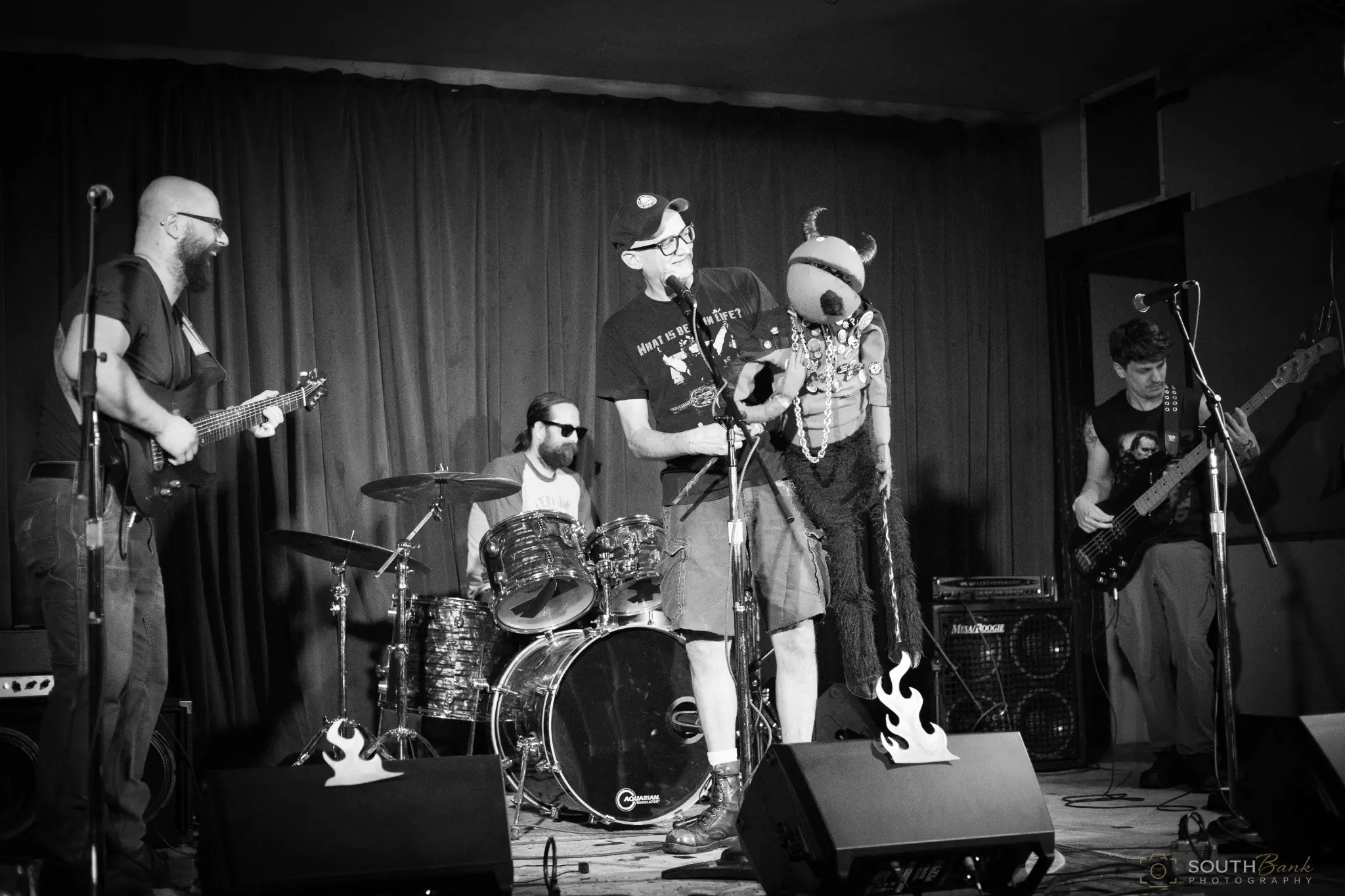Rock band performing in black and white with skeleton stage decorations