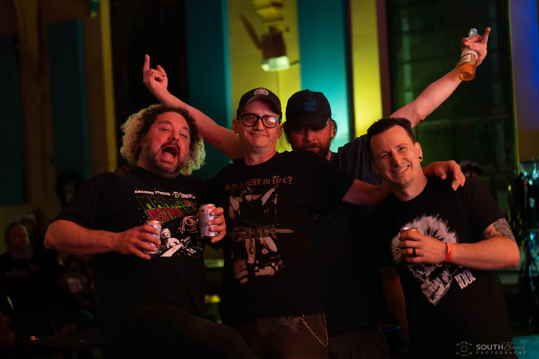 Four friends posing together during a live music event