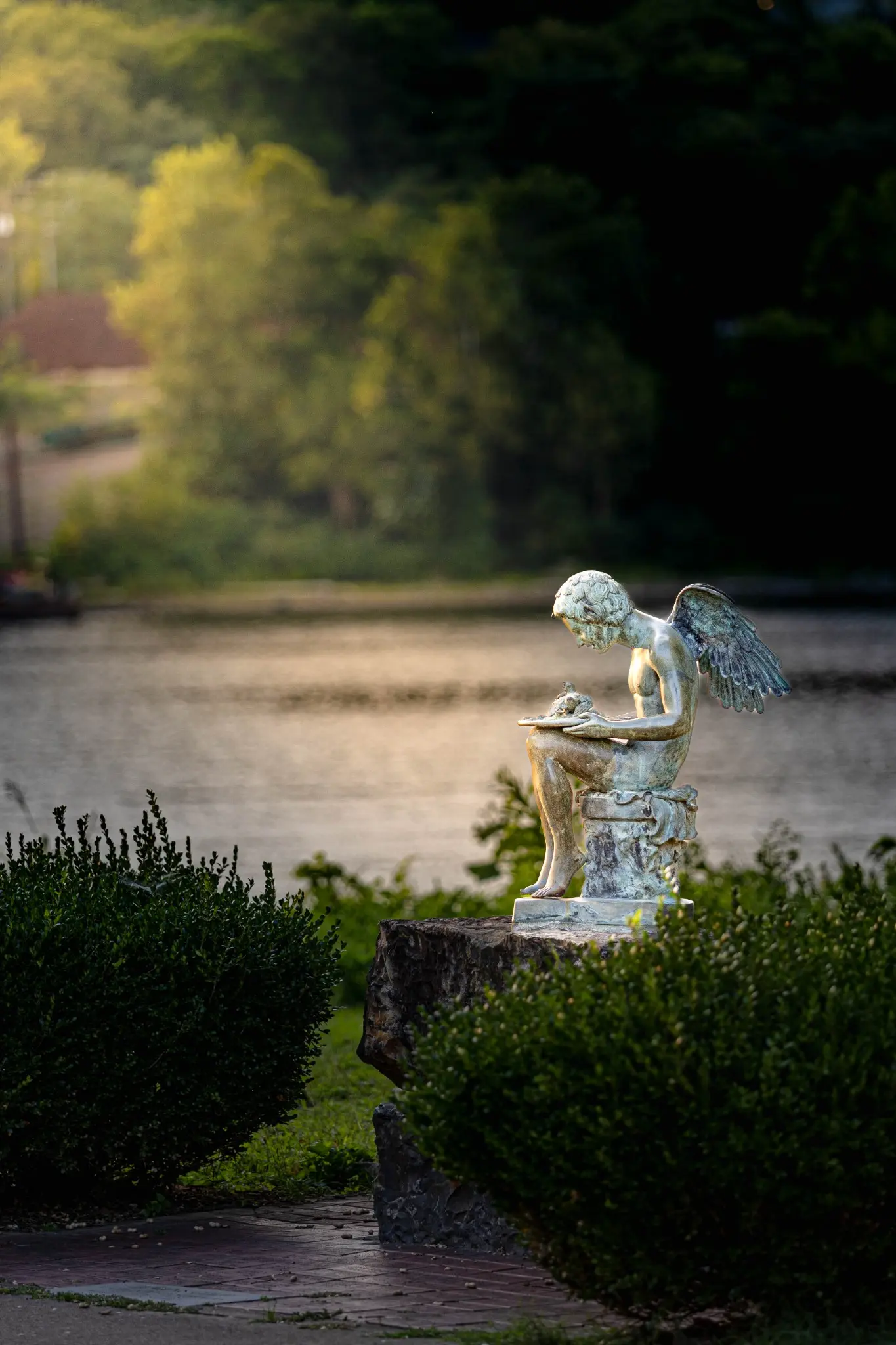 Small angel statue near the river in soft evening light